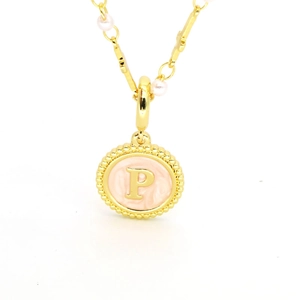Détail du collier doré avec pendentif lettre P, émail rose et perles élégantes
