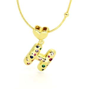Macro view of gold plated heart pendant with multicolor zircon letter H and snake chain