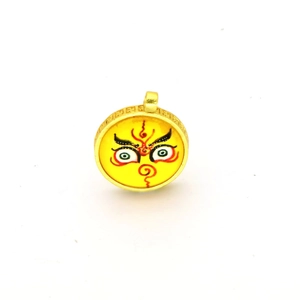 Detailed view of round golden Thangka pendant with traditional artistic eye pattern