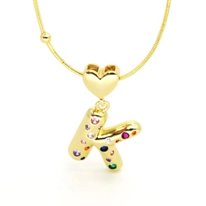 Macro detail of 18k gold plated heart pendant necklace with colorful cubic zirconia letter K