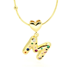 Macro detail of 18k gold heart pendant with multicolor zircon letter M on snake chain