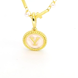 Détail du pendentif lettre Y doré avec émail rose, perles blanches et petite croix