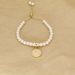 Detail of pearl bracelet with pink enamel letter W pendant and adjustable gold slider