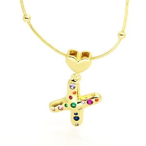 Detailed macro view of gold letter X pendant with colorful cubic zirconia and heart bail