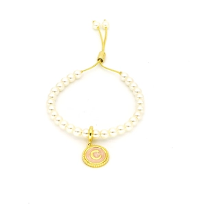 Detail of white pearl bracelet with adjustable gold chain and pink letter C charm