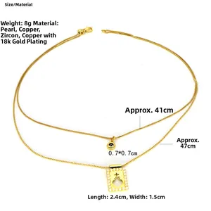 Détail du collier double rang doré montrant un pendentif perle avec découpe de croix