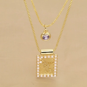 Détail d'un collier doré double couche avec pierre violette et pendentif relief ange