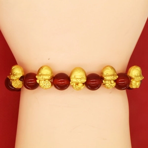 Detailed close-up of red agate beads and golden snake charms on a festive bracelet
