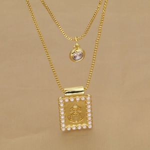 Macro de collier doré double rang avec pendentif en relief bordé de perles blanches
