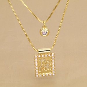 Détail d'un collier doré à deux rangs avec pierre violette et pendentif perle ajouré