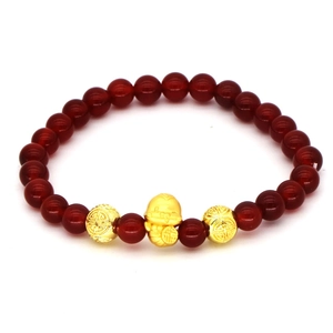 Detail of red agate beads bracelet with gold lucky cat and traditional longevity charms
