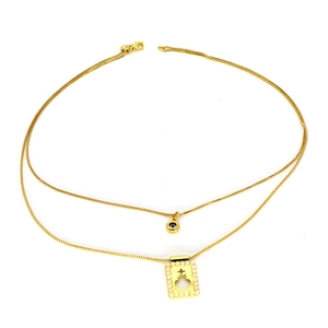 Détail d'un collier doré multicouche avec pendentif rond et pendentif perlé ajouré