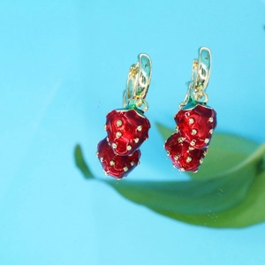 Boucles d'oreilles fraises rouges en émail avec feuilles dorées sur fond bleu éclatant
