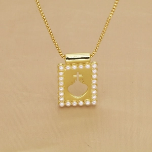 Collier doré avec pendentif rectangulaire bordé de perles et motif sacré-cœur évidé