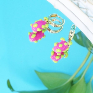 Vue détaillée de boucles d'oreilles dorées avec pendentifs pitaya roses et feuilles