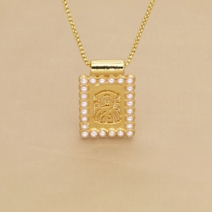 Gros plan du pendentif doré avec perles et détails gaufrés sur collier chaîne box