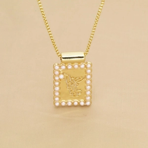 Gros plan du pendentif ange rectangulaire doré avec une bordure de perles délicates