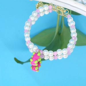 Détail du bracelet en perles avec pendentif pitaya rose et perles d'imitation