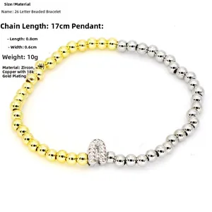 Detail view of gold and silver beaded bracelet with zircon-studded letter A charm