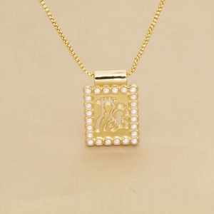 Gros plan d'un pendentif doré avec bordure en perles blanches et centre ajouré stylé