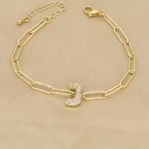 Detail of 18k gold paperclip chain bracelet featuring a zircon pavé letter J charm
