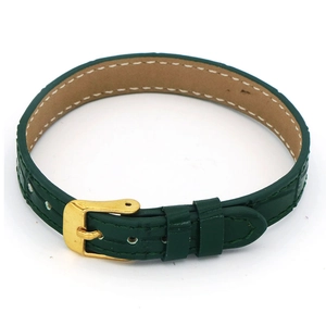 Detail of dark green crocodile leather bracelet with golden buckle and white stitching