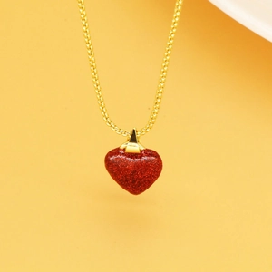 Gros plan du pendentif cœur rouge scintillant avec collier en chaîne dorée pour femme