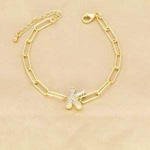Close-up of golden paperclip chain bracelet with zircon-encrusted K letter pendant