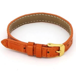 Detail of bright orange leather watch strap with white stitching and gold buckle