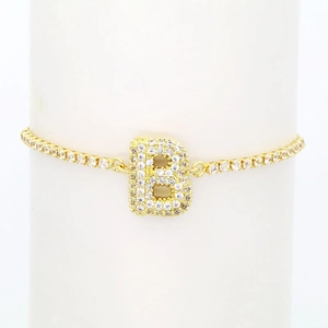 Detailed view of 18k gold tennis bracelet featuring a micro-pave zircon letter B charm