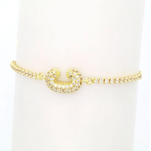 Close-up of 18k gold plated tennis bracelet with sparkling zircon horseshoe charm