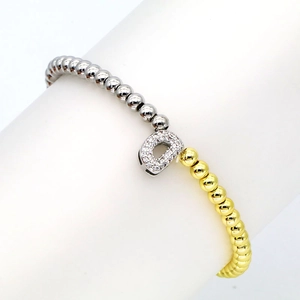 Detail of 18k gold plated beaded bracelet featuring a pave zircon letter D charm