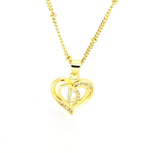 Detailed macro view of gold-plated hollow double heart necklace with crystal letter D
