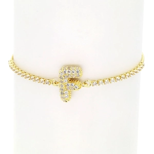 Detail of 18k gold-plated tennis bracelet with zircon-encrusted bubble letter F charm