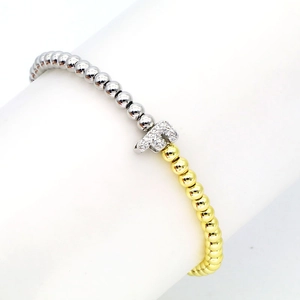 Detail of 18k gold and silver beaded bracelet with micro-pave zircon letter F charm