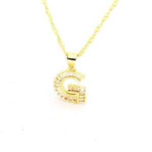 Vue macro du pendentif lettre G doré avec oxydes de zirconium et chaîne singapour