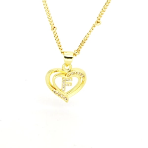 Macro shot of 18k gold plated hollow heart pendant with crystal encrusted letter F