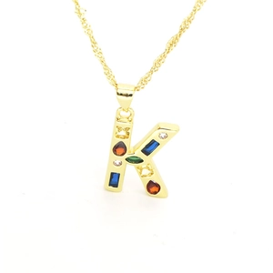 Detail view of gold-plated K-letter pendant with colorful cubic zirconia on wave chain