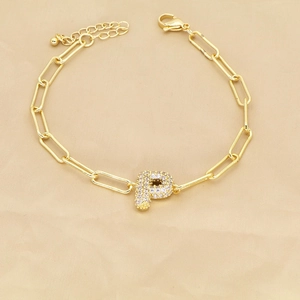 Detail of 18k gold paperclip bracelet with zircon pavé letter P pendant and clasp