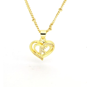 Close-up of golden heart pendant featuring a sparkling diamond-set letter K in 18k brass