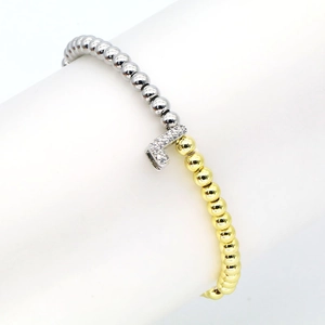 Macro shot of two-tone beaded bracelet featuring a pavé zircon number 7 charm