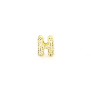 Macro shot of gold-plated letter H charm with micro-pave white zircon stones