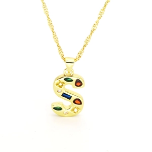 Macro shot of gold-plated S-letter pendant with multi-colored cubic zirconia stones