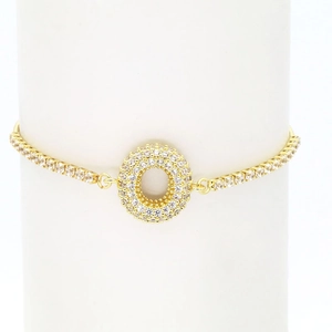 Detail of 18k gold bubble letter bracelet featuring a pavé zircon circle charm on tennis chain