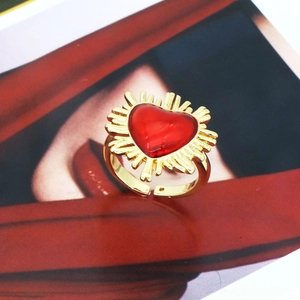 Detail of red heart ring with golden sunburst rays and adjustable open band