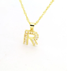 Vue détaillée du collier pendentif lettre R en or serti de zircons cubiques taille baguette