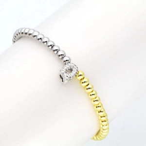 Macro detail of 18k gold and silver beads bracelet with a sparkling zircon letter Q charm
