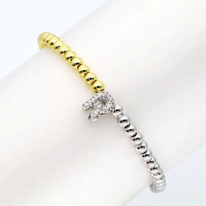 Detailed macro view of 18k gold plated stretch bracelet with zircon inlaid letter R charm