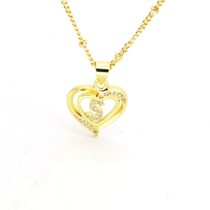 Close-up of golden heart pendant featuring letter S with sparkling zircon stones