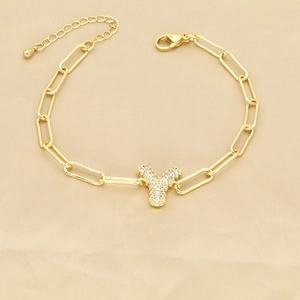 Detailed view of gold paperclip bracelet featuring a zircon-studded letter Y pendant